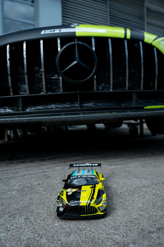 Modellauto Mercedes-AMG GT3 #11 vor dem echten Rennwagen