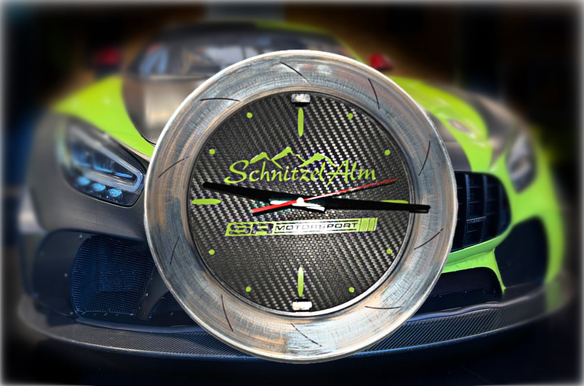 Racing-Uhr aus Bremsscheibe und Carbon vor dem Rennwagen